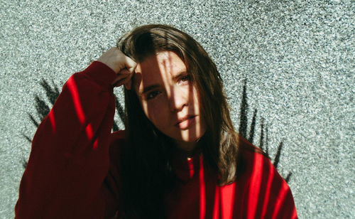 Portrait of young woman against wall