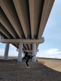 Man standing on bridge against sky