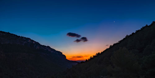 Scenic view of silhouette mountains against sky at sunset