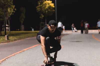 Full length of man skateboarding on street in city