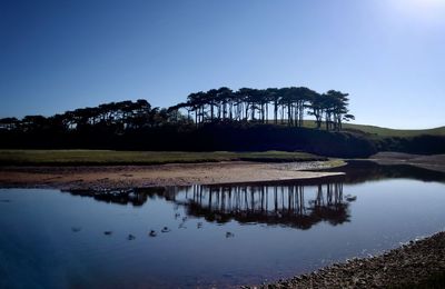 Scenic view of lake against clear blue sky