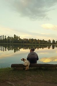 Rear view of man looking at calm lake