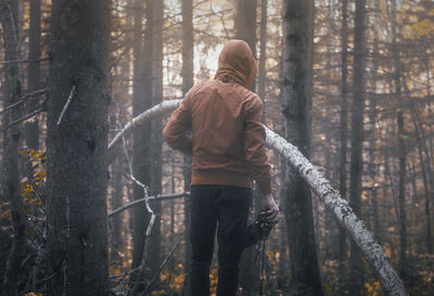 Rear view of man with camera in forest