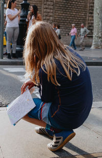 Woman with umbrella on street in city