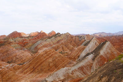 Rock formations on landscape against cloudy sky