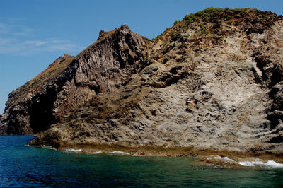 Rock formations in sea against sky