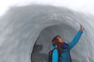 Woman looking at waterfall in winter