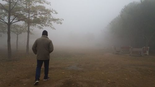 Rear view of man walking on field