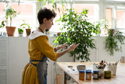 Girl artist make video of process in pottery studio of online master class workshop of shaping mug