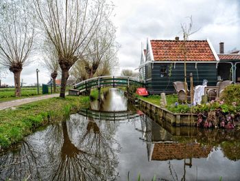 Houses by lake against sky