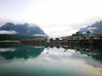 Scenic view of lake by mountains against sky