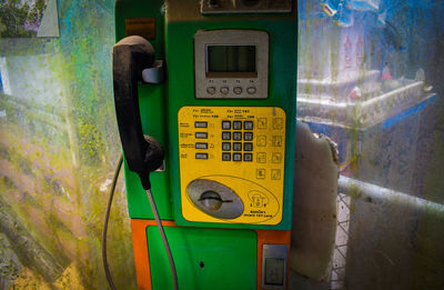 Close-up of old telephone booth on wall