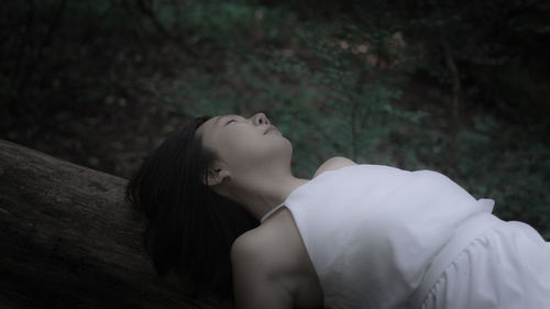 Portrait of a young woman lying on rock