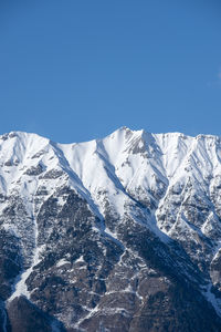 Scenic view of snowcapped mountains against clear blue sky