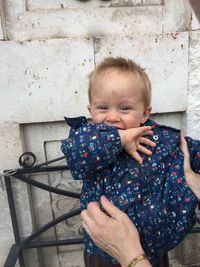 Portrait of cute boy standing against wall