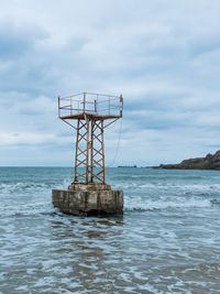 Lifeguard hut on sea against sky