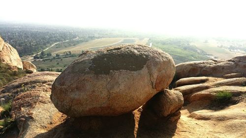 View of rocks on landscape against sky