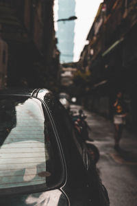 Close-up of car against sky in city