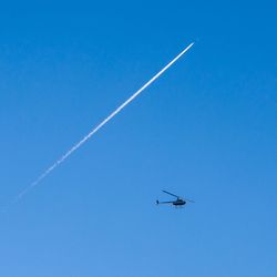 Low angle view of vapor trail against clear blue sky