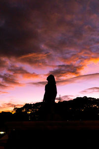 Silhouette man standing against orange sky