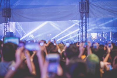 Nightlife and youth activity with backside of crowd in concert hall during show 