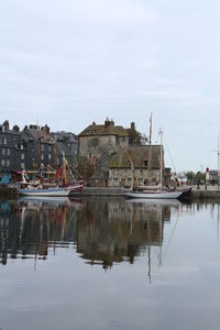 Reflection of houses in sea against sky