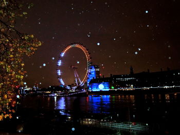 Illuminated ferris wheel at night