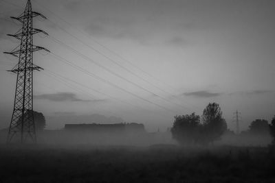 Electricity pylon on field against sky