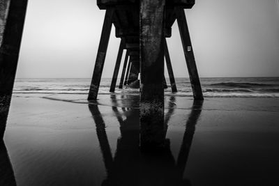 Wooden pier on sea against clear sky