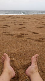 Low section of man legs on sand at beach