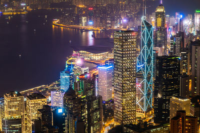 Illuminated buildings at victoria harbour in city during night