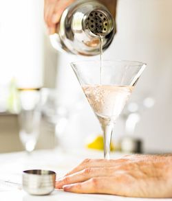 Cropped hand making drink at table