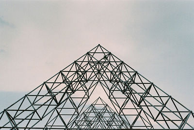 Low angle view of silhouette electricity pylon against sky
