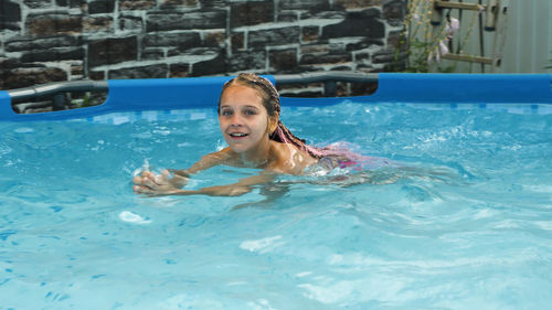 Portrait of young woman swimming in pool