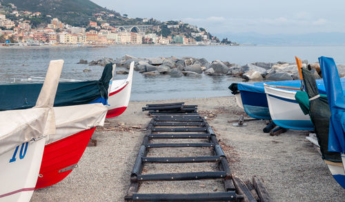 Deck chairs on beach against buildings in city