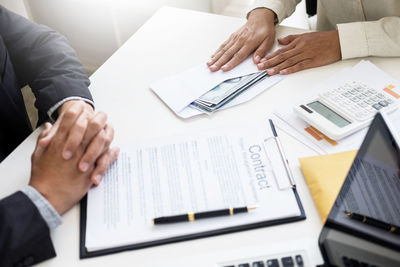 Midsection of man using laptop on table