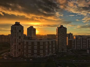 View of cityscape against cloudy sky during sunset