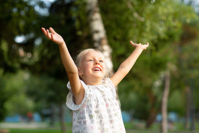 Girl playing with bubbles in park