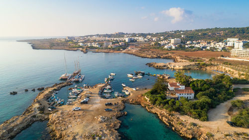 High angle view of townscape by sea against sky