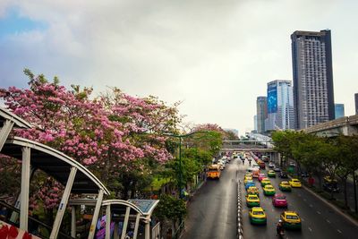 Cars moving on road against cloudy sky
