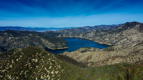 Scenic view of lake and mountains against blue sky