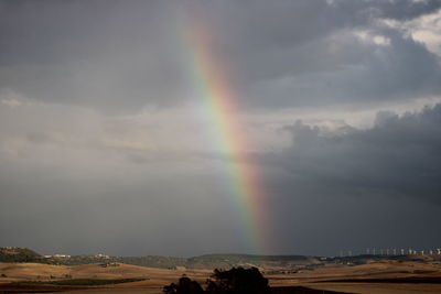 Rainbow over landscape against sky