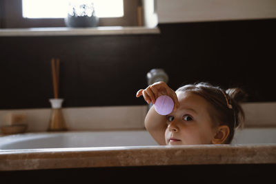 Child holding bath bomb. relaxing hygiene procedure for kids. aromatherapy and fun at home. happy