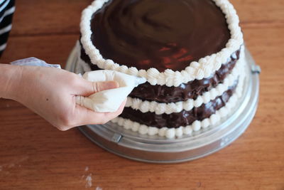 Close-up of hand holding chocolate cake