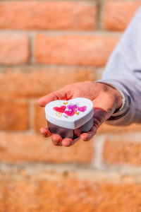 Hand holding heart-shaped gift box