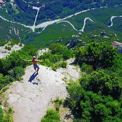 High angle view of man jumping on mountain