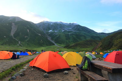 Tents on field against mountains