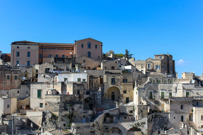 Buildings in city against clear blue sky