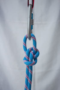 Close-up of rope tied on metal against wall