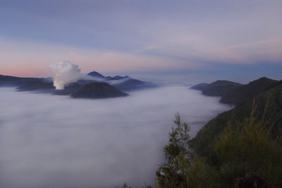 Smoke emitting from volcanic mountain against sky